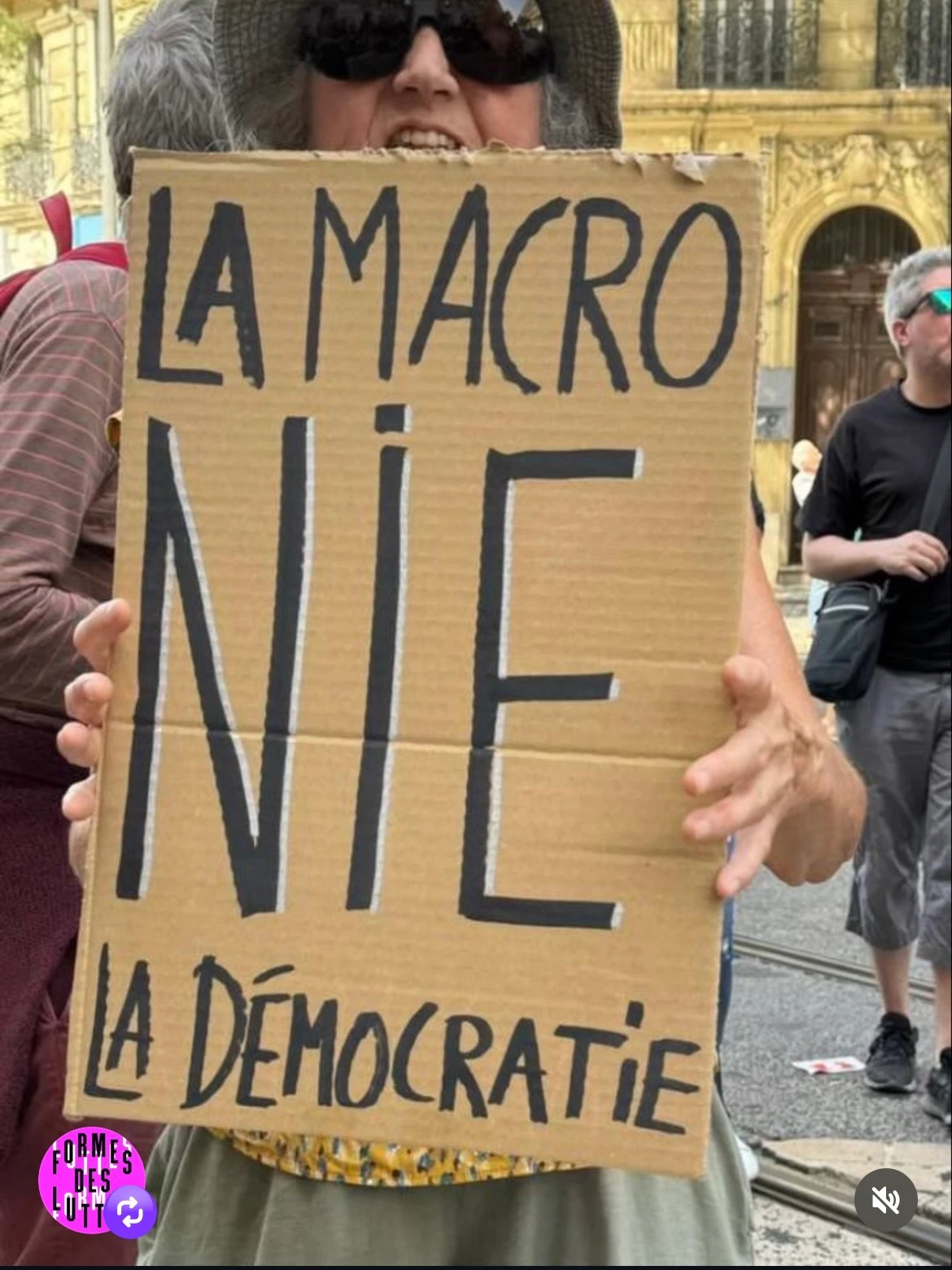 Protest sign reading: LA MACRO NIE LA DÉMOCRATIE
