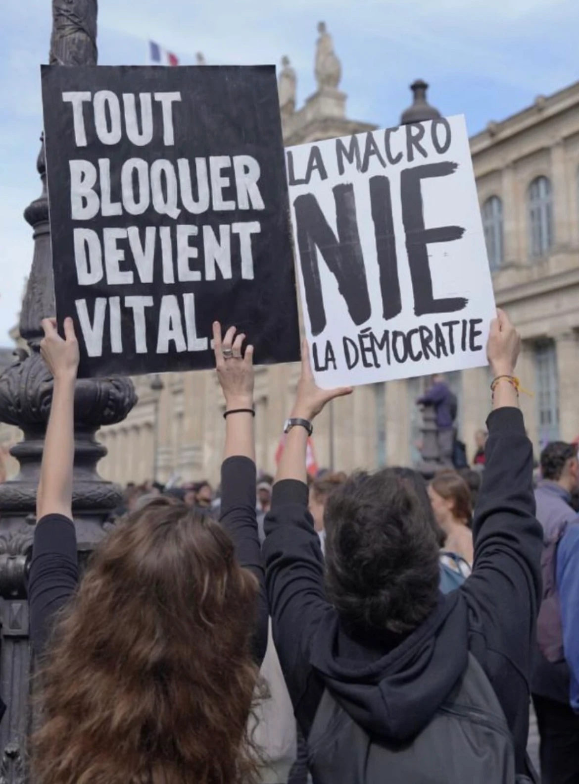 Protest sign reading: TOUT BLOQUER DEVIENT VITAL